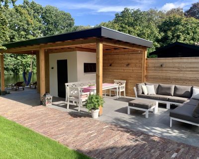 Uitbreiding van bestaande schuur naar overkapping tijdens tuinrealisatie in Woerden.